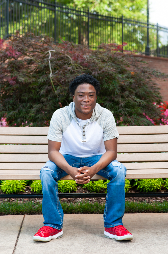 Young man sitting on bench and leaning forward